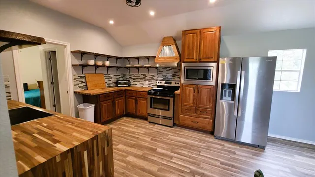 a kitchen with stainless steel appliances granite countertop a refrigerator and a stove top oven