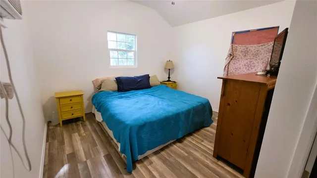 a bedroom with a bed and wooden floor