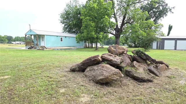 a view of a house with backyard and a tree