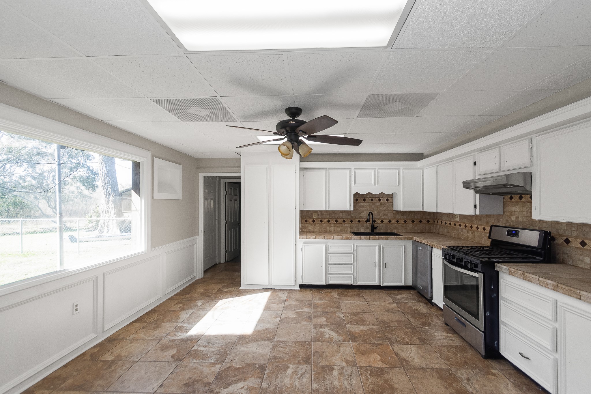 6830 South Highway 35 Alvin, TX 77511 - Photo 4 of 24 a kitchen with a sink a counter top space stainless steel appliances and a large window