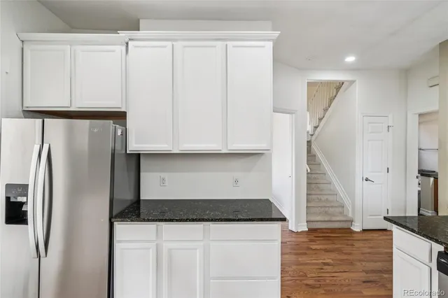 a kitchen with white cabinets and refrigerator