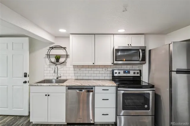 a kitchen with appliances a sink and cabinets
