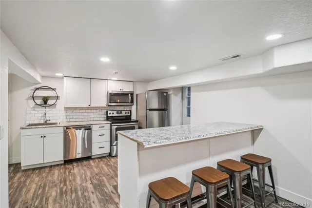 a kitchen with stainless steel appliances granite countertop a sink stove and refrigerator