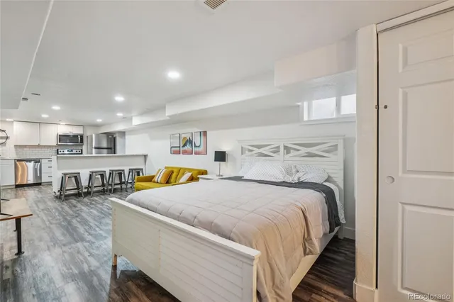 a spacious bedroom with a bed a table and potted plant on the table