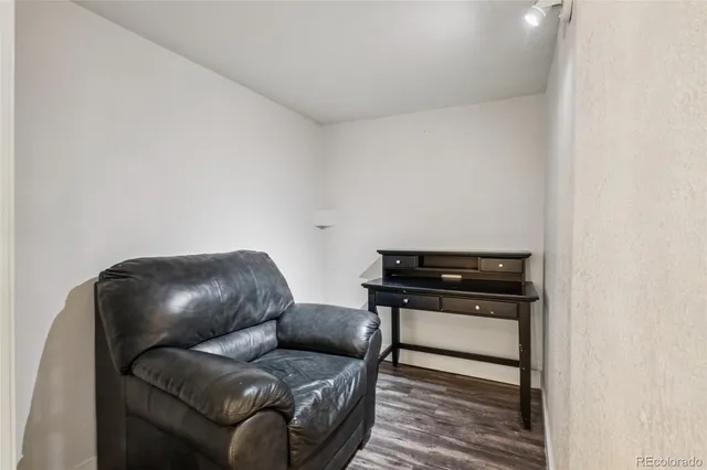 a living room with a couch and a stove with wooden floor