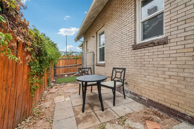 a backyard of a house with table and chairs