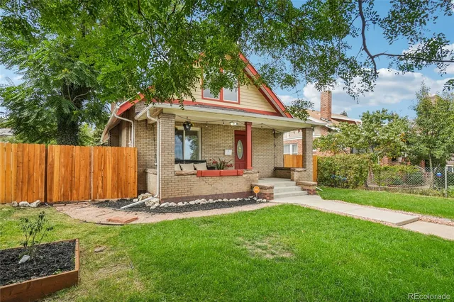 a view of a house with backyard and a tree
