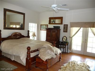 21180 North River Road Alva, FL 33920 - Photo 9 of 10 a bedroom with a bed a table and chair with the outer view