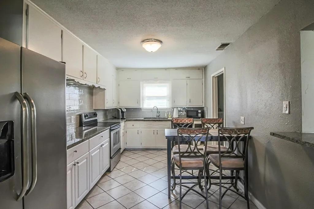 3011 37th Street Lubbock, TX 79413 - Photo 5 of 11 a kitchen with appliances cabinets and chair