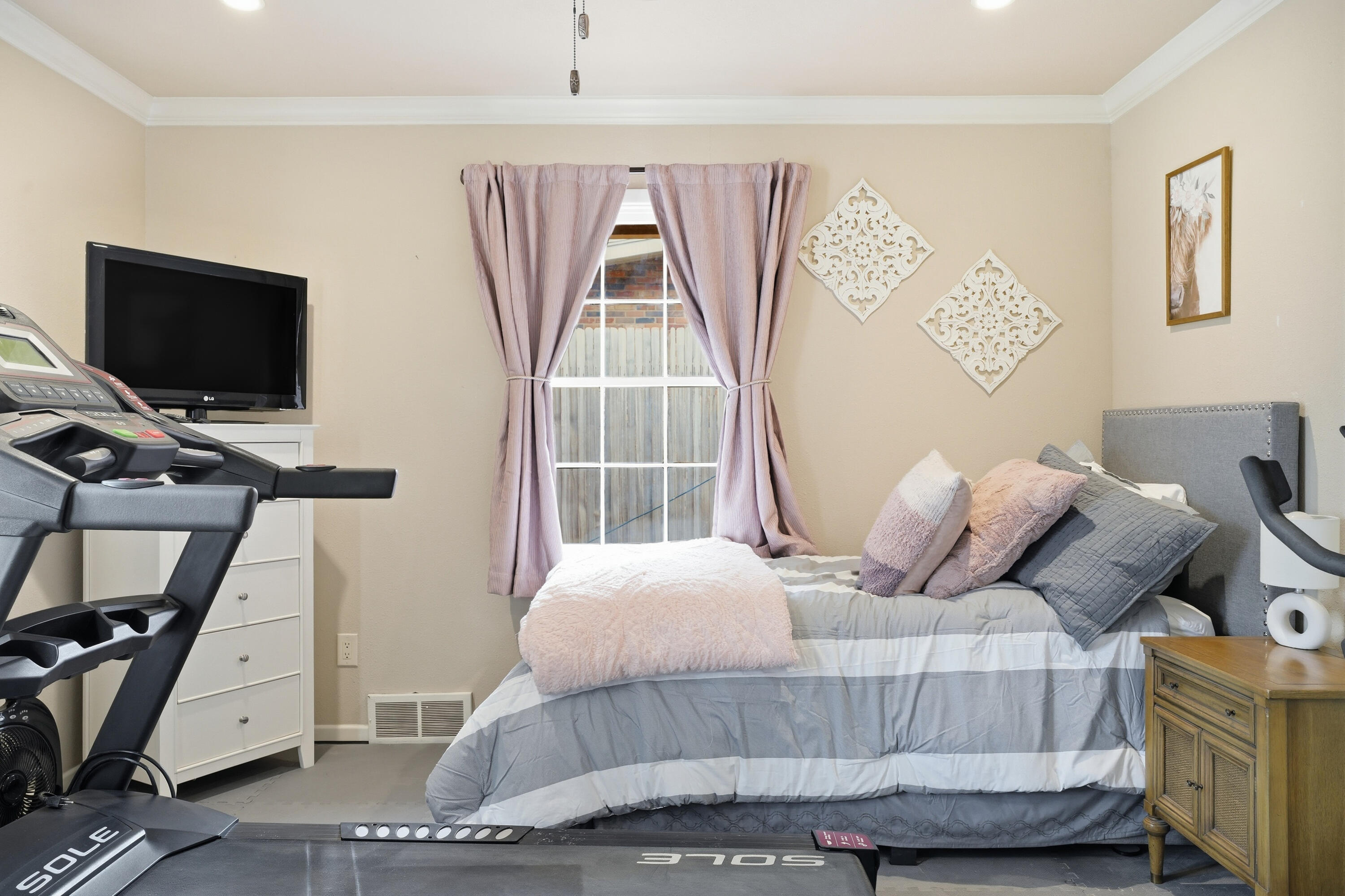 4602 13th Street Lubbock, TX 79416 - Photo 29 of 54 a bedroom with a bed and a flat tv screen