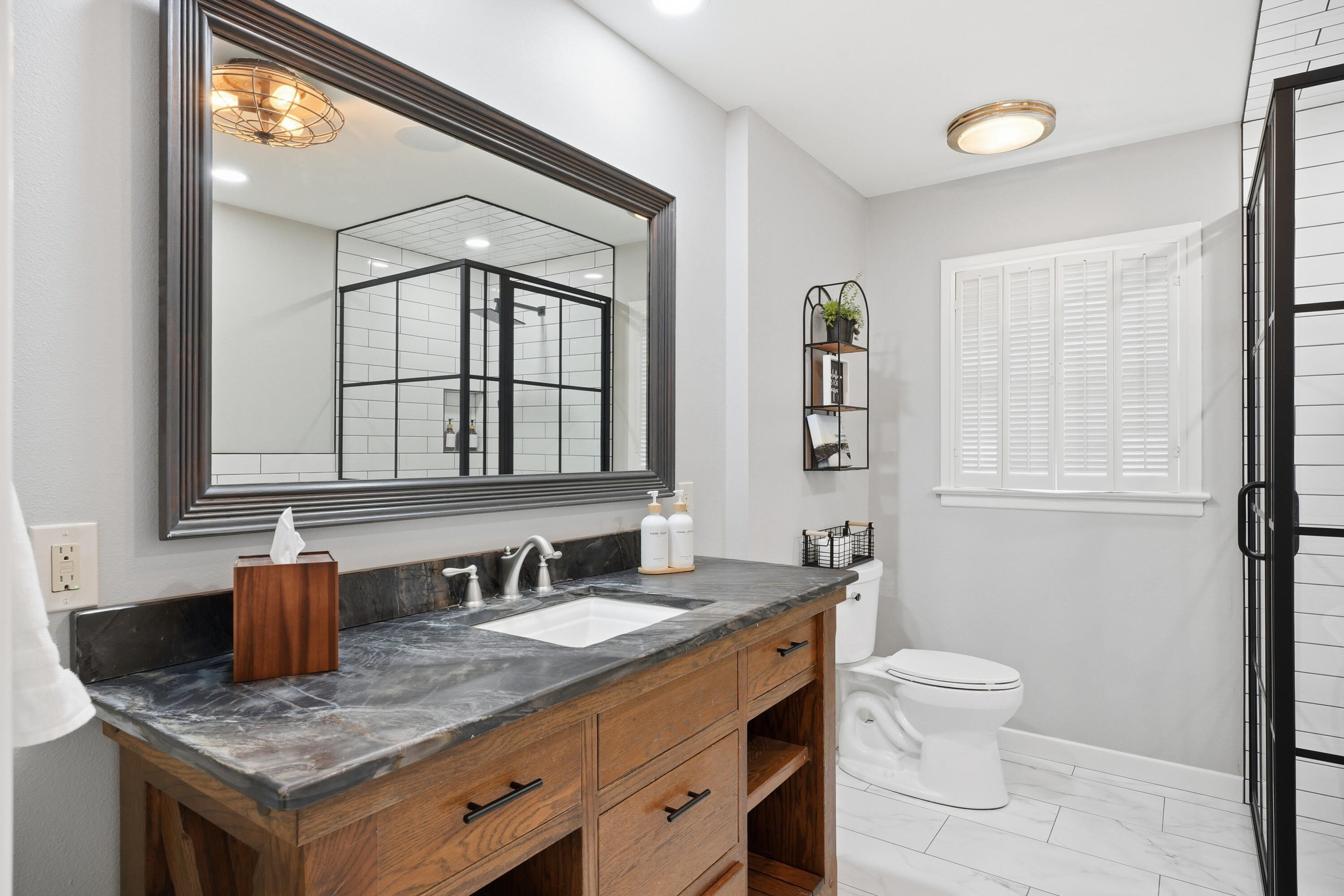 4602 13th Street Lubbock, TX 79416 - Photo 32 of 54 a bathroom with a granite countertop sink and a mirror