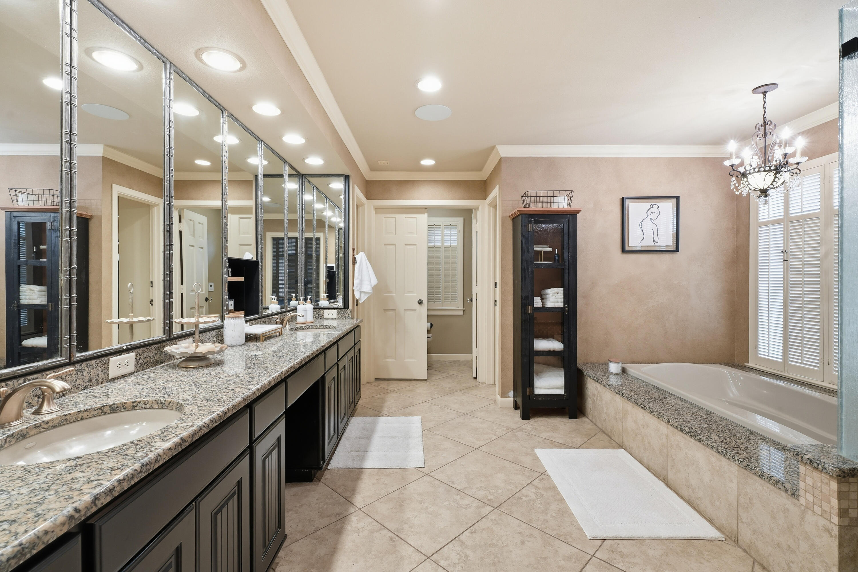 4602 13th Street Lubbock, TX 79416 - Photo 42 of 54 a large bathroom with a granite countertop sink and a large mirror