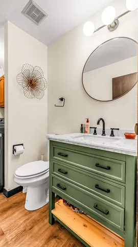 a bathroom with a toilet a sink and mirror