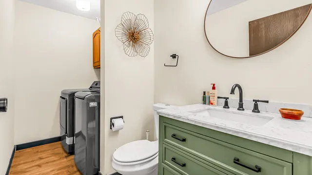 a bathroom with a granite countertop toilet sink and mirror