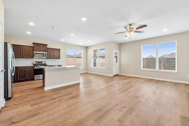 a view of kitchen with kitchen island a sink stainless steel appliances and cabinets