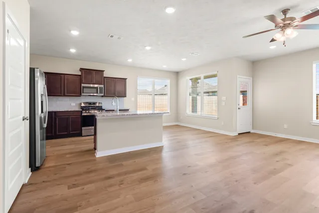 a view of kitchen with kitchen island a sink stainless steel appliances and cabinets