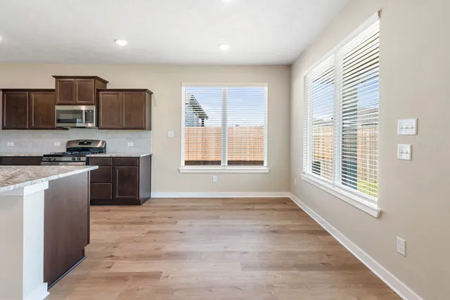 a kitchen with stainless steel appliances granite countertop a stove a sink and a refrigerator
