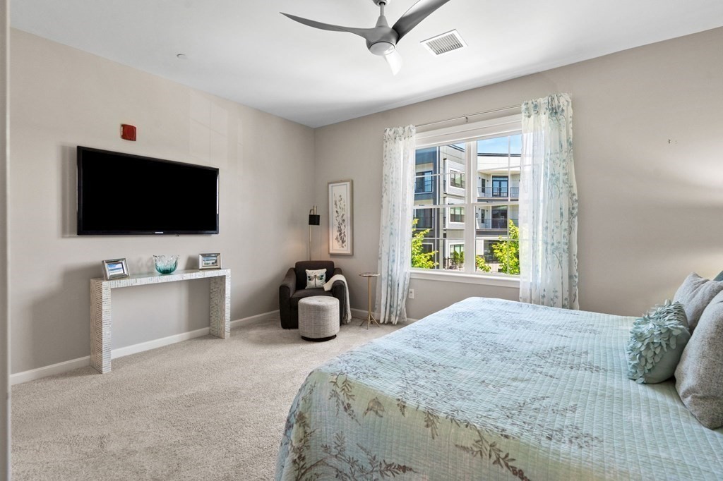 1 Revolution Way, Unit 201 Canton, MA 02021 - Photo 14 of 38 a bedroom with a bed and a flat tv screen on dresser