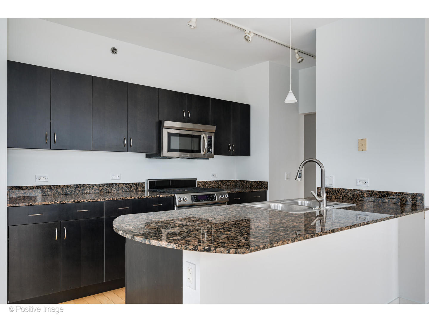 8 East Randolph Street, Unit 2808 Chicago, IL 60601 - Photo 6 of 22 a kitchen with granite countertop a sink and a stove top oven with wooden floor