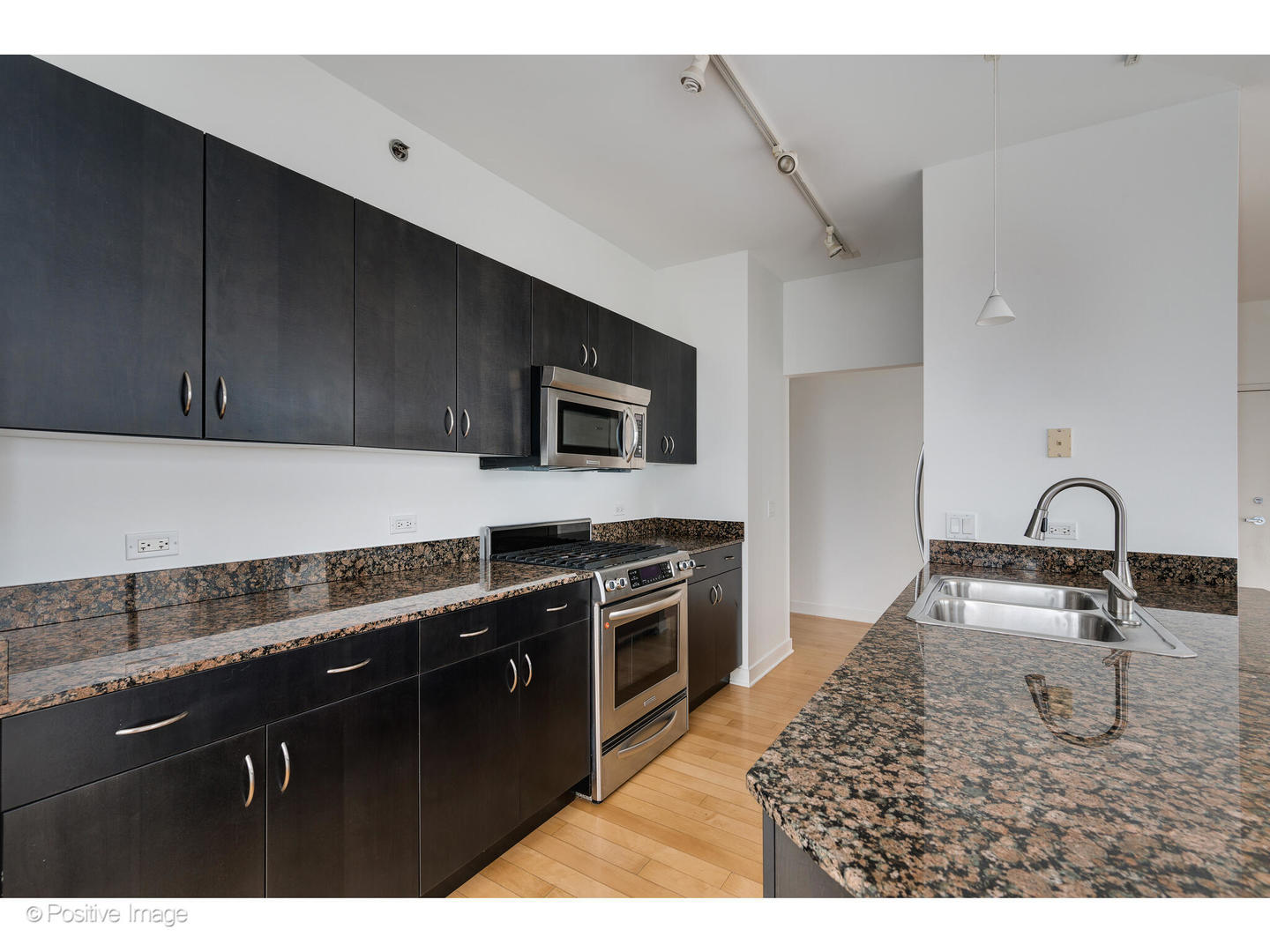 8 East Randolph Street, Unit 2808 Chicago, IL 60601 - Photo 7 of 22 a kitchen with kitchen island granite countertop a sink stainless steel appliances and cabinets