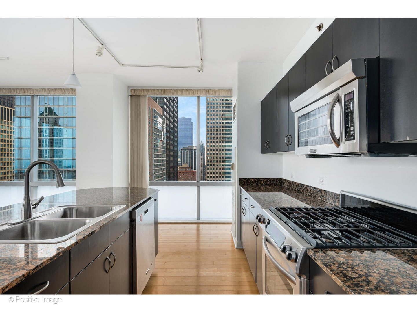 8 East Randolph Street, Unit 2808 Chicago, IL 60601 - Photo 8 of 22 a kitchen with granite countertop a sink and a stove top oven