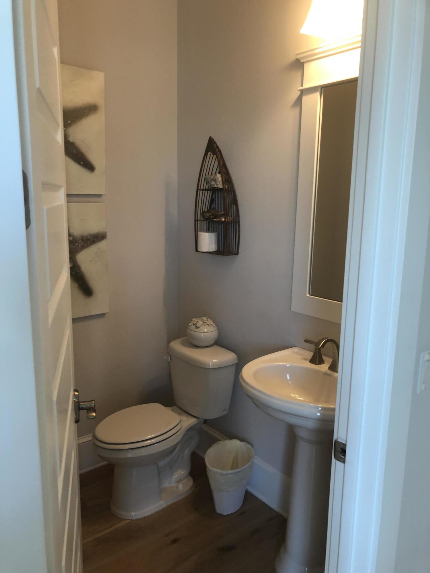 59 East Crabbing Hole Ln Inlet Beach Inlet Beach, FL 32461 - Photo 38 of 62 a white toilet sitting next to a bathroom sink and vanity