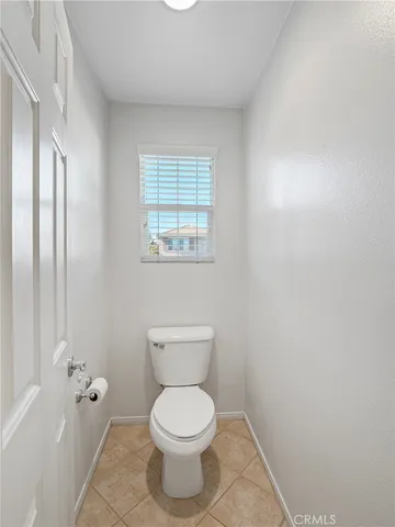 a white toilet sitting next to a bathroom sink and vanity