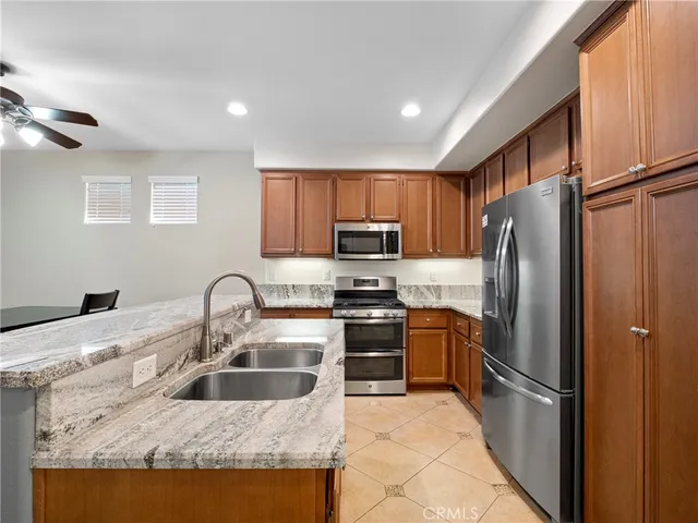 a kitchen with stainless steel appliances granite countertop a refrigerator sink and stove