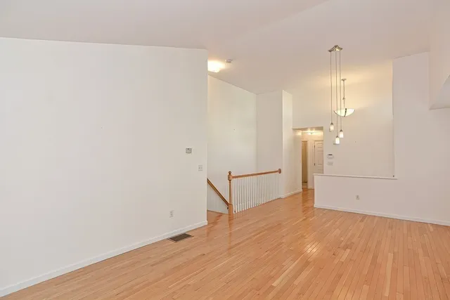 a view of a room with wooden floor and white walls