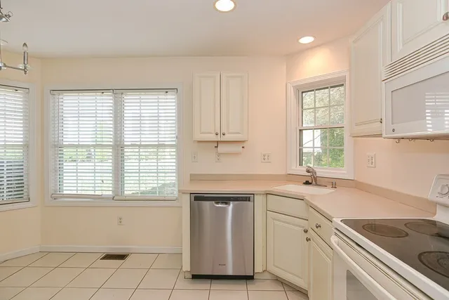 a kitchen with a sink cabinets appliances and a window
