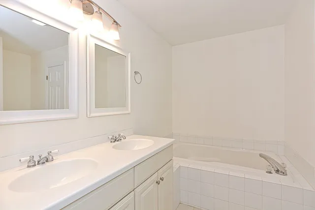a bathroom with a granite countertop sink a mirror and a bathtub