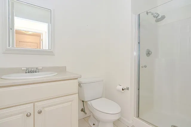 a bathroom with a granite countertop toilet a sink and a mirror