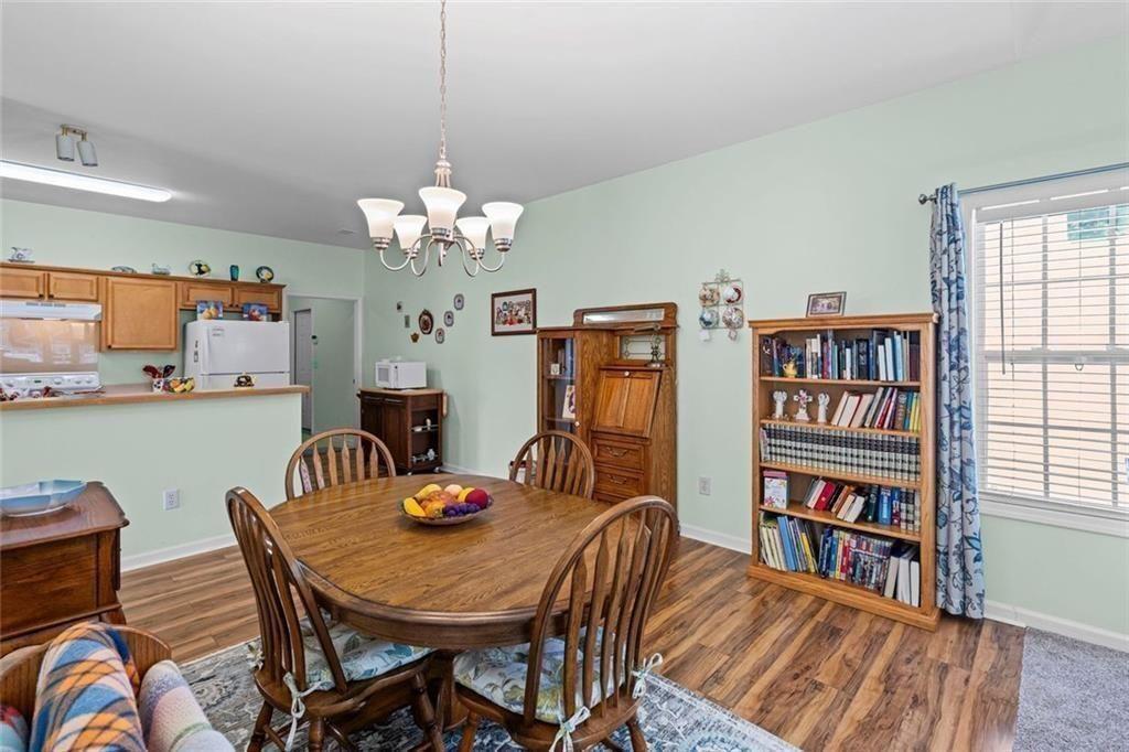 460 Tribble Gap Road, Unit 102 Cumming, GA 30040 - Photo 13 of 21 a dining room with furniture a rug and wooden floor