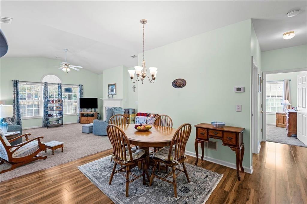 460 Tribble Gap Road, Unit 102 Cumming, GA 30040 - Photo 14 of 21 a view of a livingroom and dining room with furniture wooden floor a chandelier