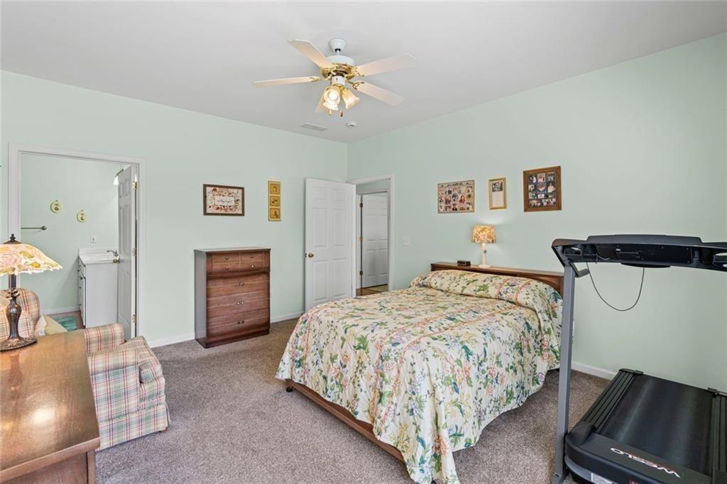 460 Tribble Gap Road, Unit 102 Cumming, GA 30040 - Photo 18 of 21 a bedroom with a bed and a chandelier
