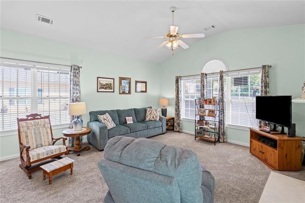 460 Tribble Gap Road, Unit 102 Cumming, GA 30040 - Photo 5 of 21 a living room with furniture and a flat screen tv