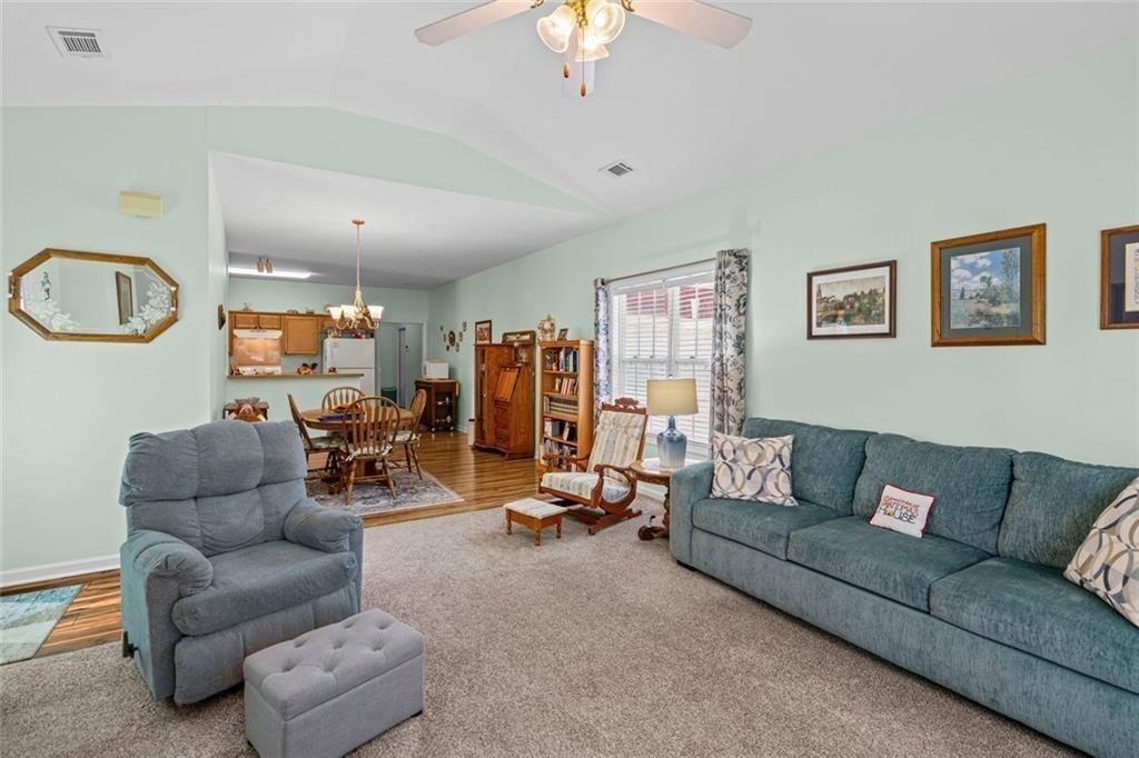 460 Tribble Gap Road, Unit 102 Cumming, GA 30040 - Photo 8 of 21 a living room with furniture and a chandelier