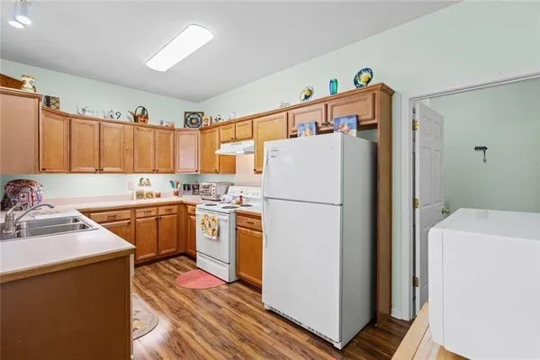 a kitchen with a refrigerator sink and wooden cabinets