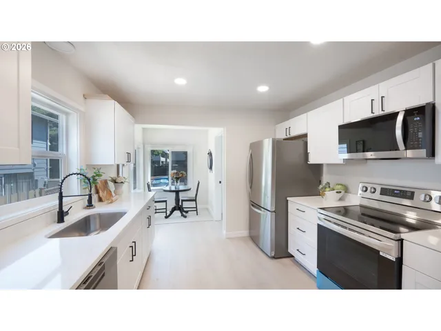a kitchen with stainless steel appliances a microwave a sink a stove and cabinets