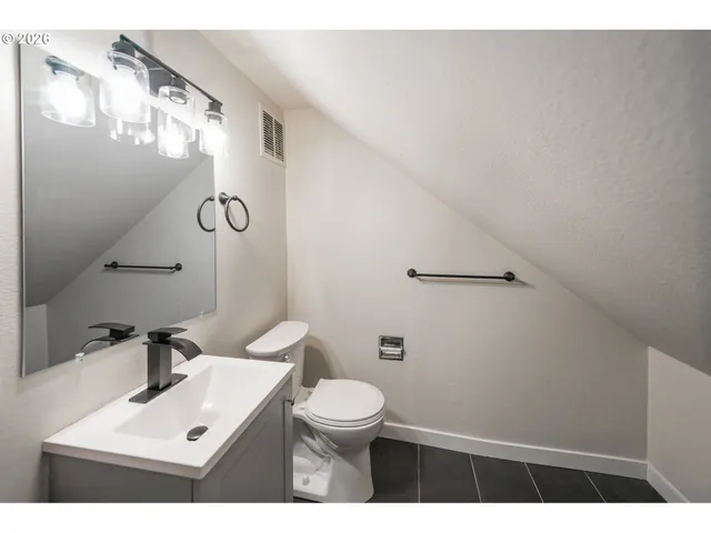 a bathroom with a sink mirror vanity and toilet