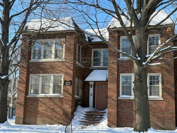 a front view of a house with a tree