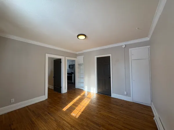 a view of empty room with wooden floor