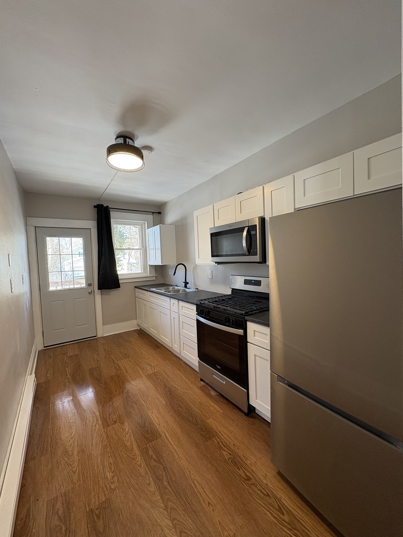 905 North Sheridan Road, Unit F Peoria, IL 61606 - Photo 5 of 11 a kitchen with stainless steel appliances granite countertop a refrigerator and a sink