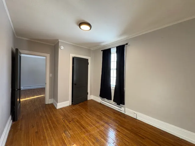an empty room with wooden floor and closet