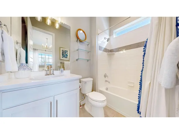 a bathroom with a sink a toilet a mirror a vanity and shower
