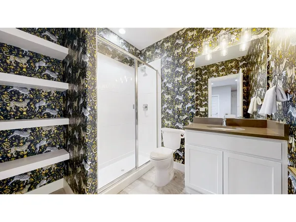 a bathroom with a sink a toilet and shower