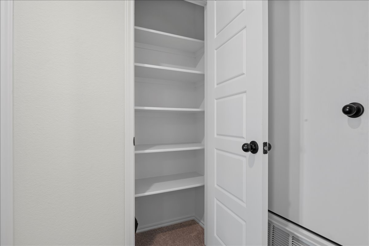 18501 Spotted Eagle Lane Elgin, TX 78621 - Photo 24 of 40 A well-organized linen closet features built-in shelving, providing ample storage.