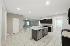 a kitchen with a sink and a stove top oven with wooden floor