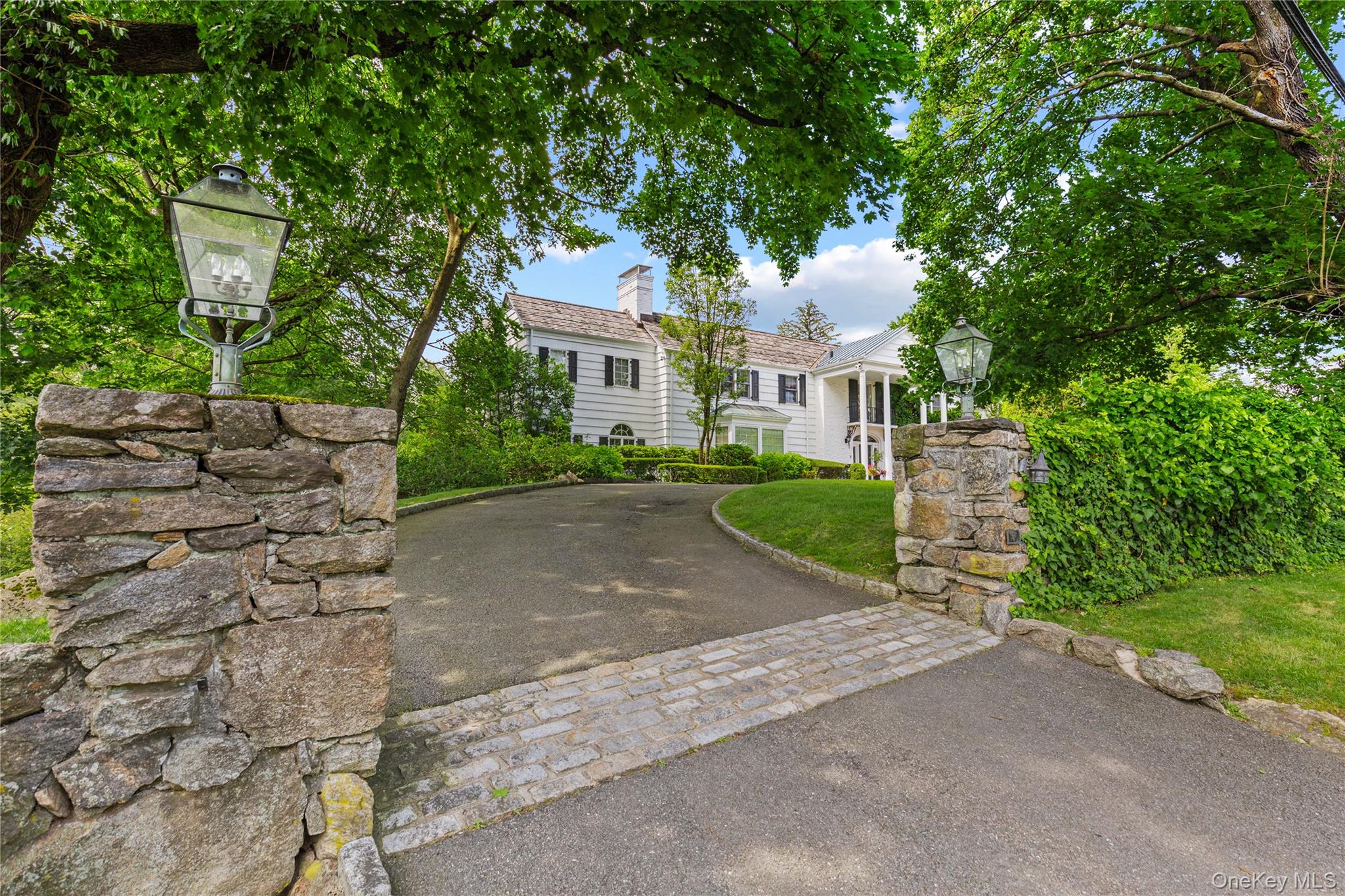 25 Stratford Road Harrison, NY 10528 - Photo 3 of 47 a front view of a house with a garden and trees