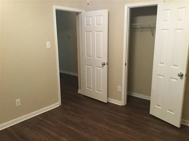 an empty room with wooden floor and closet